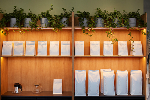 Background image of shelves in coffee shop or tea cafe with mockup craft paper bags, copy space