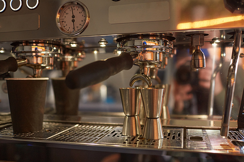 Closeup background image of industrial coffee machine making espresso in cafe or coffee shop, copy space
