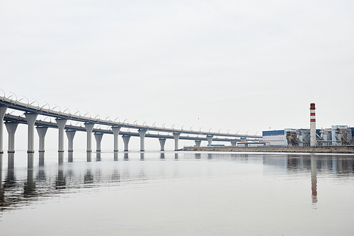 Wide angle background image of industrial production area with bridge by water, copy space