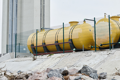 Wide angle background image of industrial area outdoors with yellow storage tanks, ecology and pollution concept, copy space