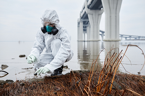 Full length portrait of scientist wearing hazmat suit collecting soil samples, , eco and pollution concept, copy space