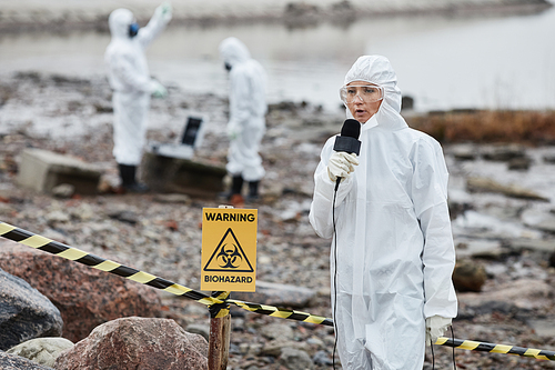Portrait of woman wearing protective suit protesting toxic waste and pollution at ecological disaster site, copy space
