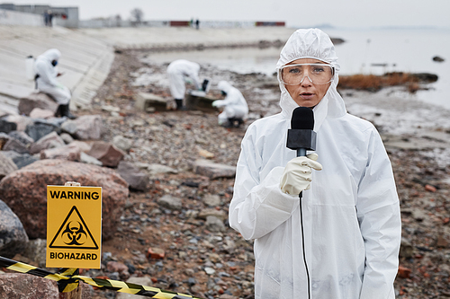 Waist up portrait of woman wearing protective suit protesting toxic waste and pollution at ecological disaster site, copy space