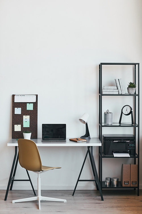 Vertical background image of minimal home office workplace with laptop and accessories in black and white, copy space