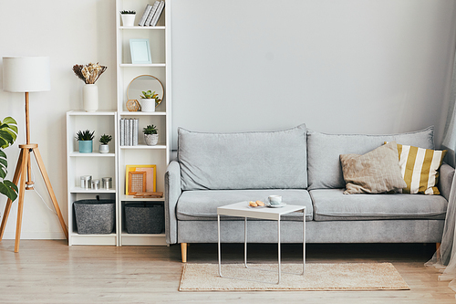 Minimal background image of cozy home interior with comfortable sofa in airy grey and white tones, copy space