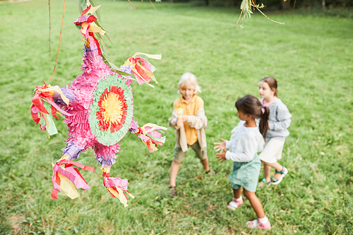 Background image of pink pinata at Birthday party with diverse group of kids playing outdoors, copy space