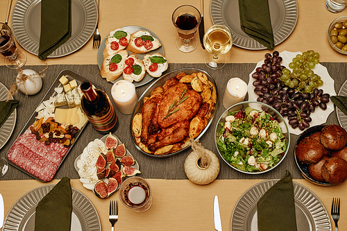 High angle view of roast turkey with salad and appetizers on dining table for dinner