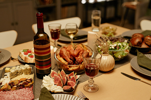 Close-up of bottle of red wine with turkey and appetizers on the dining table served for holiday