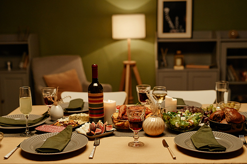 Close-up of food and bottle of wine on dining table for dinner party in the living room