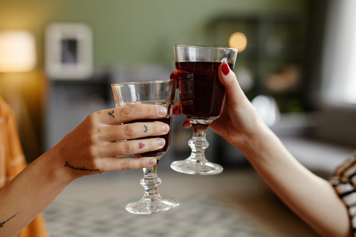 Close-up of friends holding glasses with red wine and toasting together during celebration the holiday