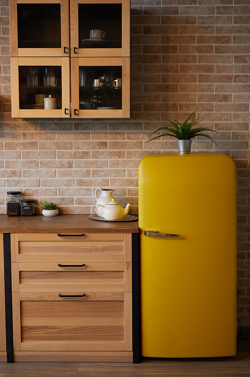 Vertical background image of kitchen interior with brick wall and yellow retro fridge, copy space