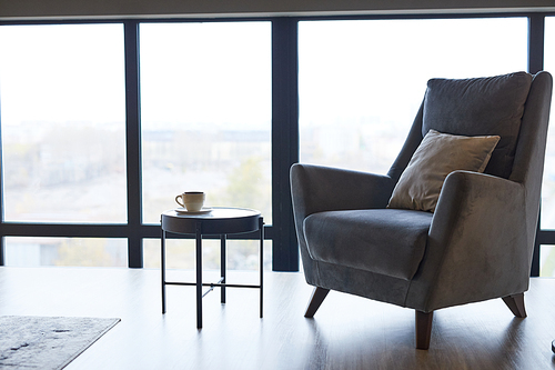 Background image of cozy grey armchair against window in minimal home interior, copy space