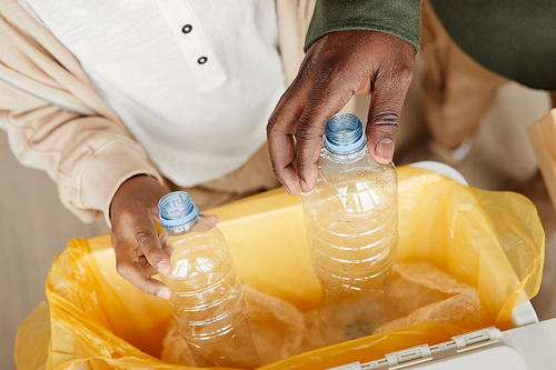 Close up of father and son sorting household waste at home together, copy space