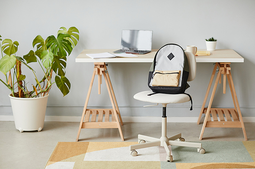 Minimal background image of school backpack by desk in home interior, copy space