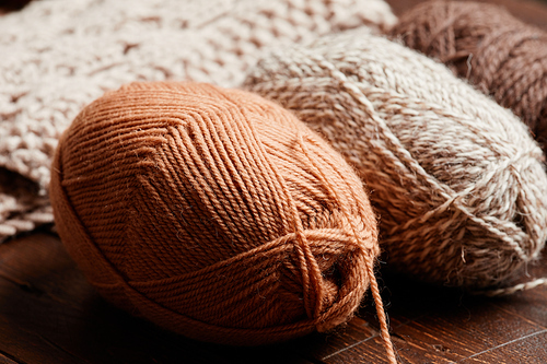 Close up of neutral colored wool on dark wooden background, knitting and hobby, copy space