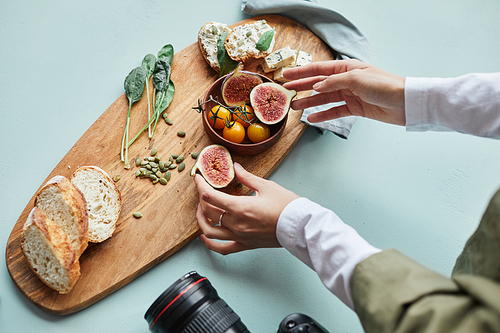 Close up of female food photographer arranging gourmet dish with props while working in studio, copy space