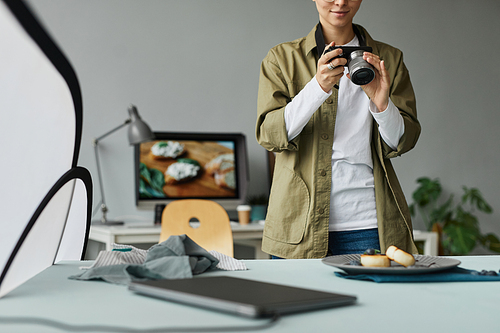 Cropped portrait of young food photographer taking pictures in studio, digital creator concept