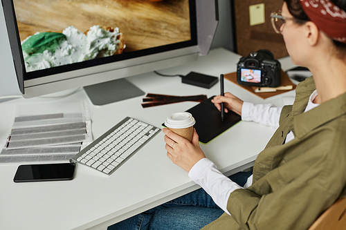 Cropped shot of young female photographer editing pictures at workplace in studio using pen tablet