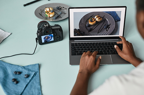 Close up of food photographer editing pictures using laptop in studio, copy space