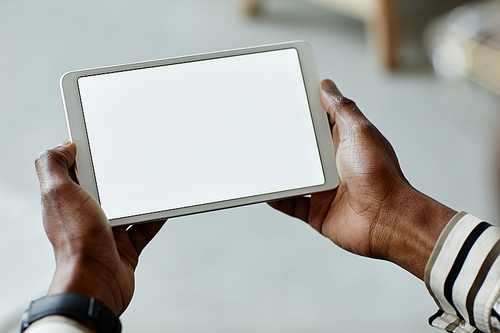 Close up of African American man holding tablet with blank screen while operating smart home devices, copy space