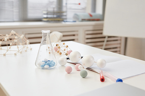 Minimal background image of glass beakers and molecule models on table in chemistry class at school, copy space