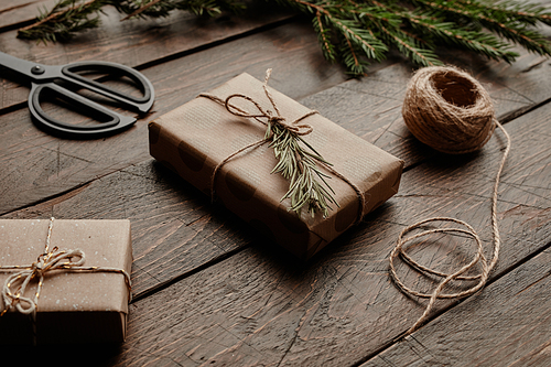 Close up background image of minimal Christmas gift box wrapped in craft paper on wooden table, copy space