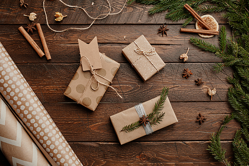 Top view background of Christmas presents wrapped in craft paper on rustic wooden table, copy space