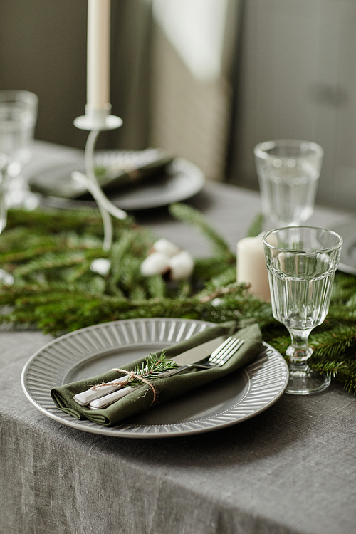 Vertical background image of dining room table decorated for Christmas with fir tree branches and candles, copy space