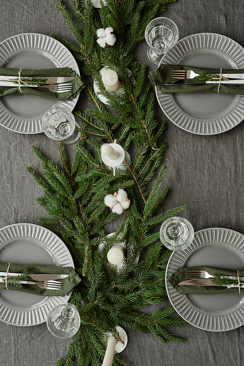 Top view background image of dining room table decorated for Christmas with fir tree branches and candles, copy space