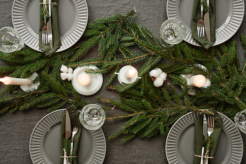 Top view background of elegant dining table decorated for Christmas in grey tones, copy space