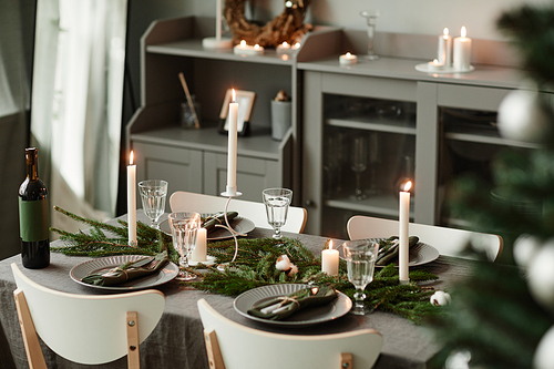 Background image of elegant dining table decorated for Christmas in minimal grey and silver tones, copy space