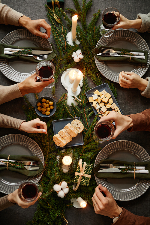 Top view background of four people enjoying Christmas dinner together while sitting by elegant dining table with candles lit, copy space