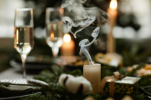 Close up of elegant white candle on Christmas dining table with smoke waving , copy space