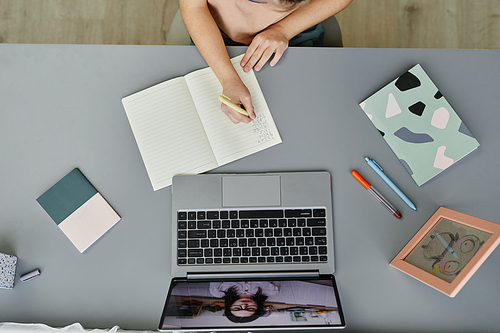 Top view background of unrecognizable child studying at home with focus on desk with online lesson on laptop screen, copy space