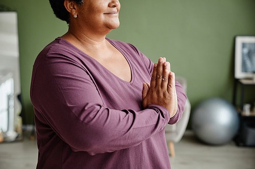 Close up portrait of black senior woman meditating at home and smiling, copy space