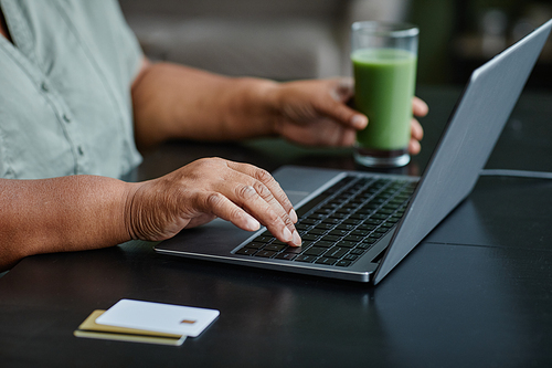 Close up of black senior woman using laptop at home and shopping online, copy space