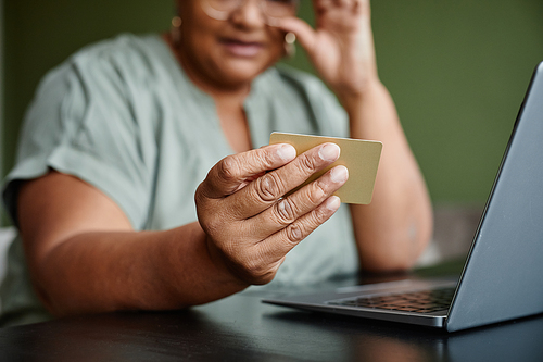 Close up of black senior woman holding credit card and shopping online, copy space