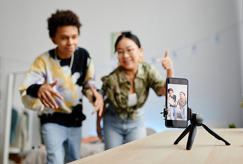 Background image of two gen Z teenagers filming video for social media, focus on smartphone screen, copy space