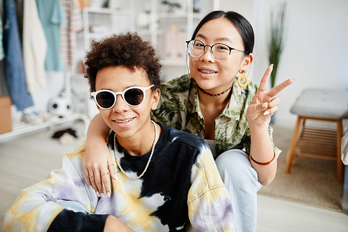 Portrait of two trendy teenagers boy and girl posing to camera in home interior