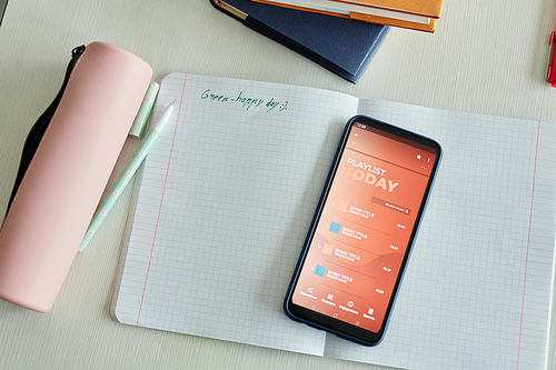 Top view background of notebook and smartphone on childs desk in school classroom, copy space