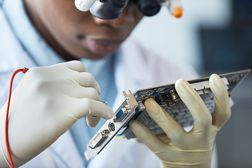 Close up of female engineer inspecting hardware part in laboratory