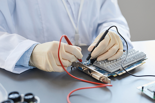 Close up of lab technician checking hardware parts at quality control station, copy space