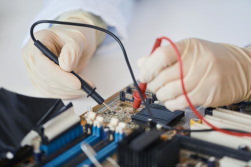 Macro shot of female engineer working with electronic parts in laboratory, copy space