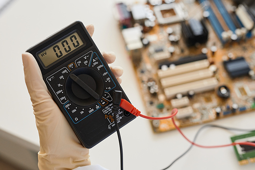 Close up of female engineer holding multimeter tool in laboratory, copy space