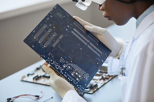 Close up of female engineer technician inspecting computer parts in quality control lab