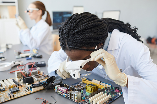 Portrait of black of female engineer inspecting computer parts in quality control lab