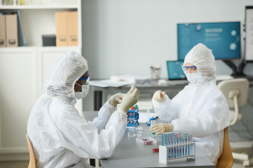 Portrait of young black woman wearing protective gear while working in medical laboratory