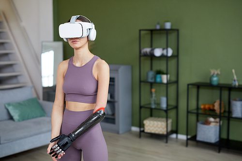 Young girl with disability using virtual reality glasses during sport training at home