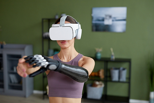 Young woman in virtual reality glasses training in the room at home