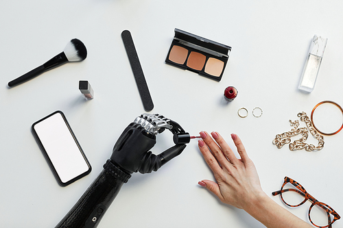 High angle view of girl with disability painting her nails with nail polish